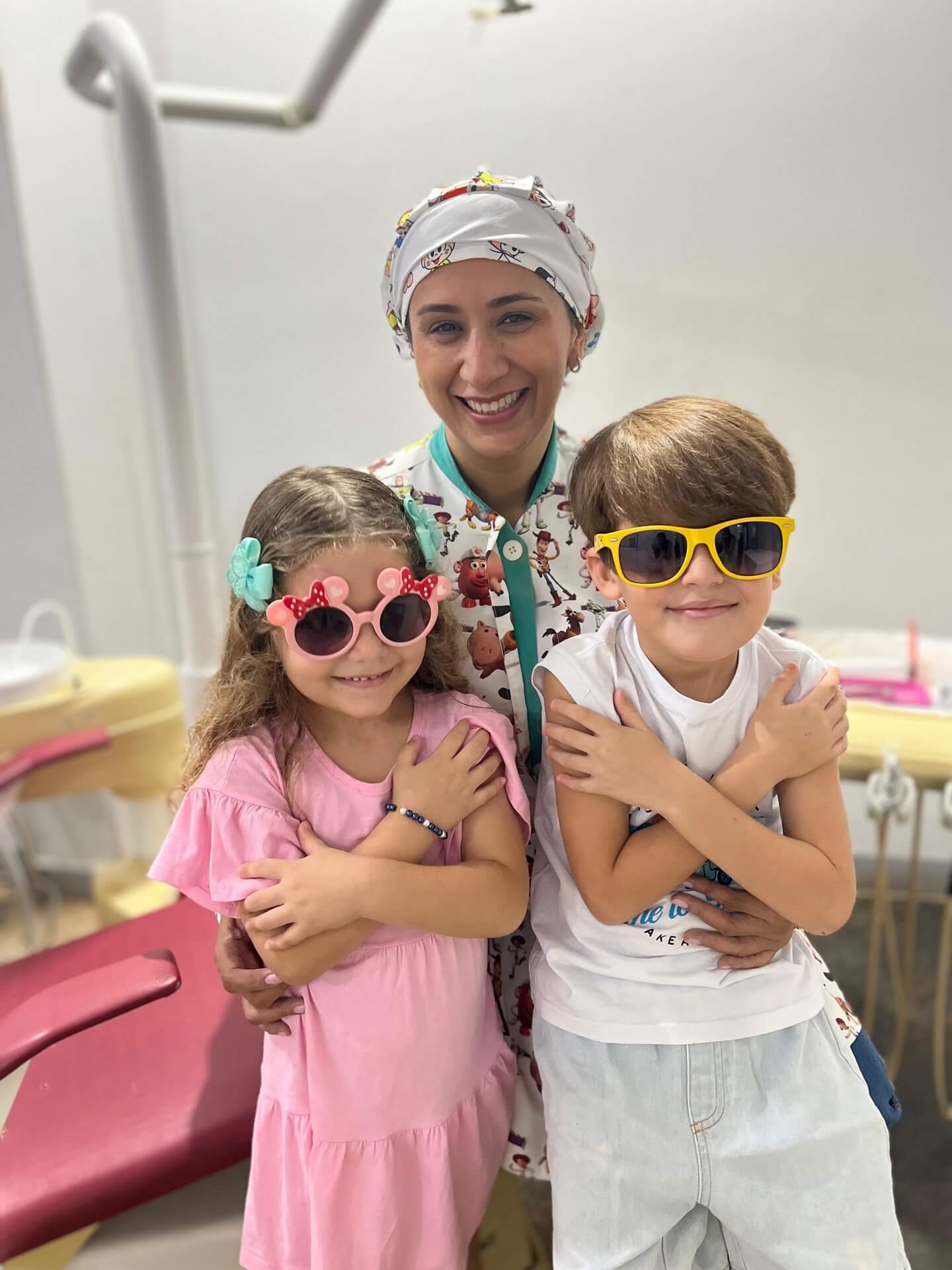 Dra. Ederlene com duas crianças no consultório da Odontoclínica